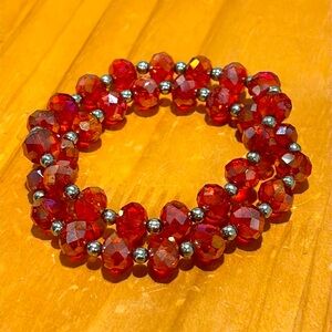 Pair of red (leaning orange) glass bead bracelets with silver bead accents.